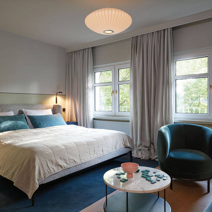 37_stilwerkhotels_heimhude_zimmer_bett_sessel_tisch_wittmann_leuchte_hay_-c-_stilwerk_t-baermann_15_700pixel